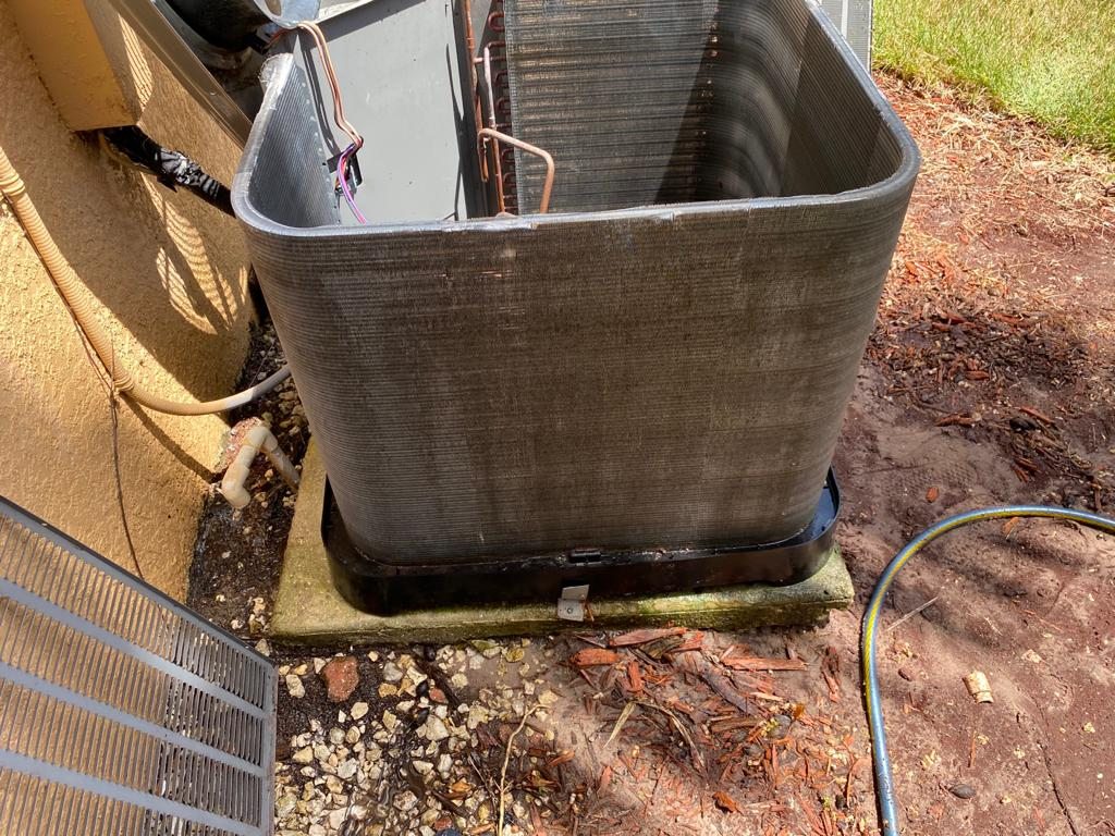 The same condenser coil after washing, with clean aluminum fins visible.