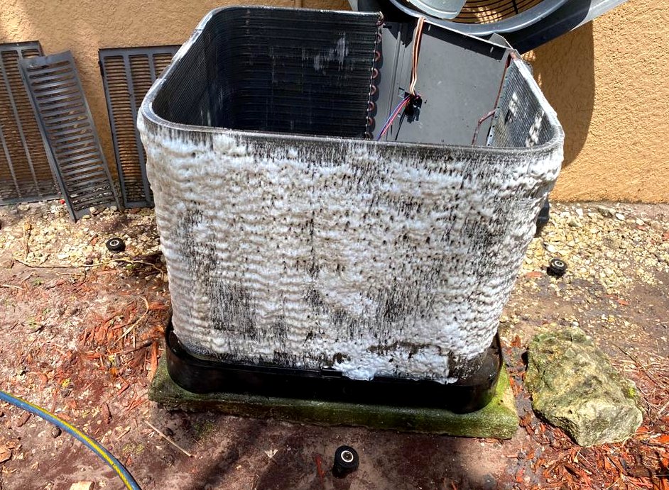 Foaming coil cleaner applied to a condenser coil, running brown as it lifts the dirt.