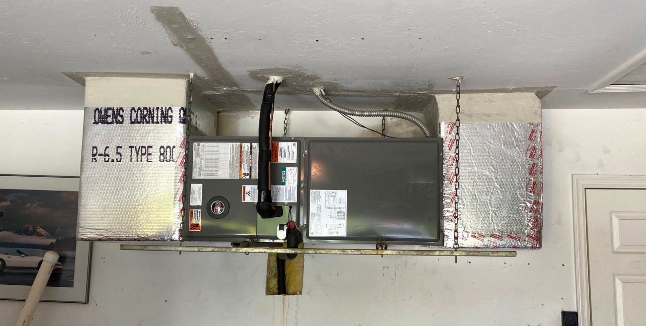 Ceiling air handler tied into existing ductwork with new sealed transitions.