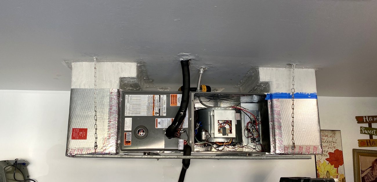 Air handler with the service panel removed, showing the blower assembly and control wiring.