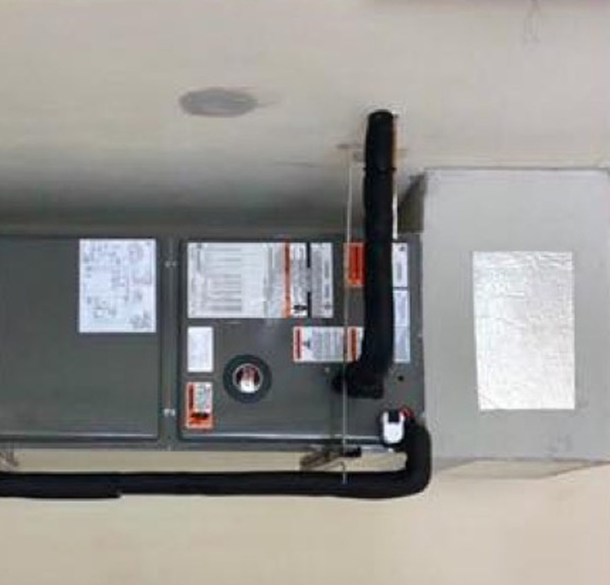 Finished air handler installation with insulated line set and clean drain routing.