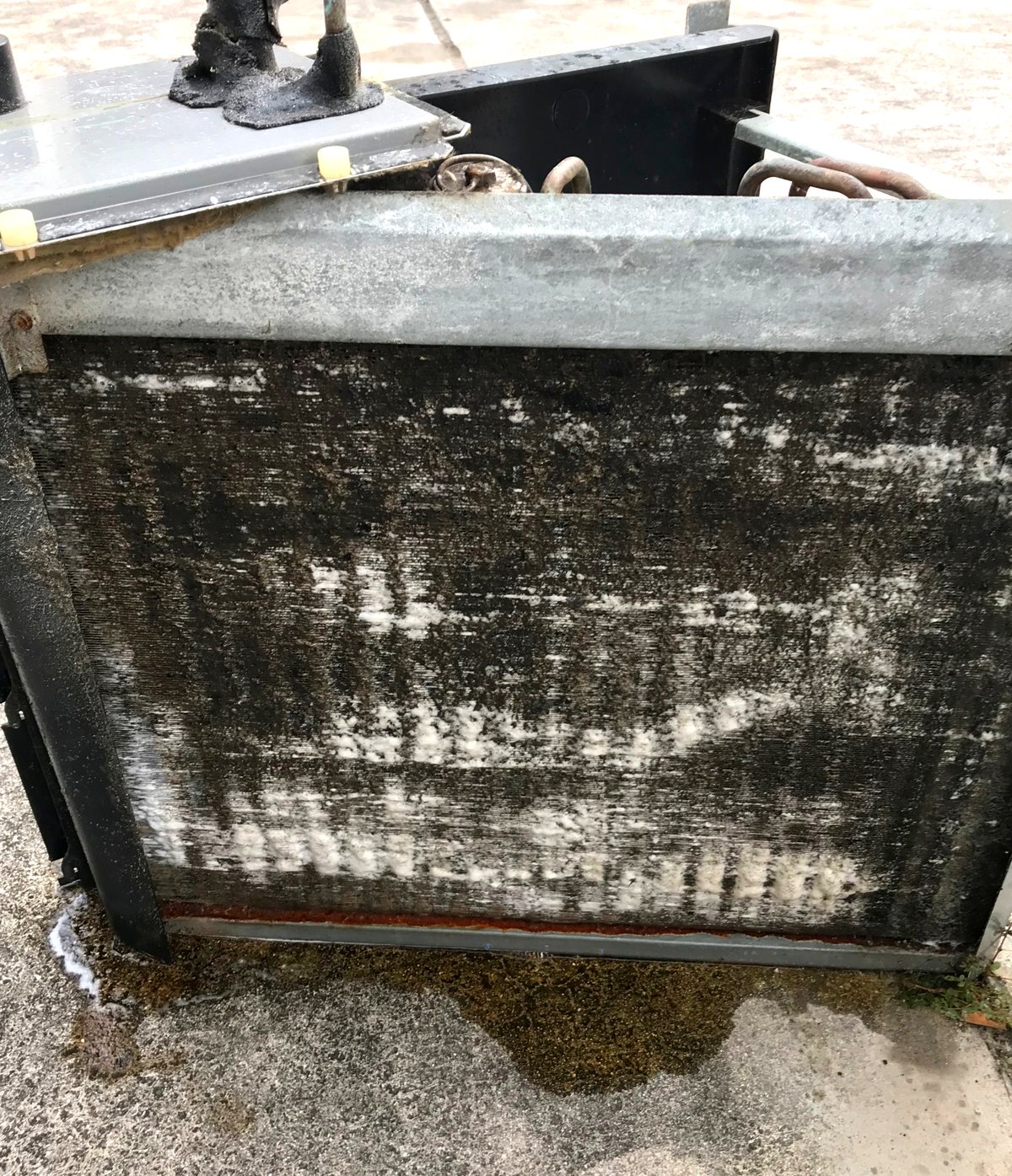 Foaming cleaner covering the removed evaporator coil, running off the bottom edge.
