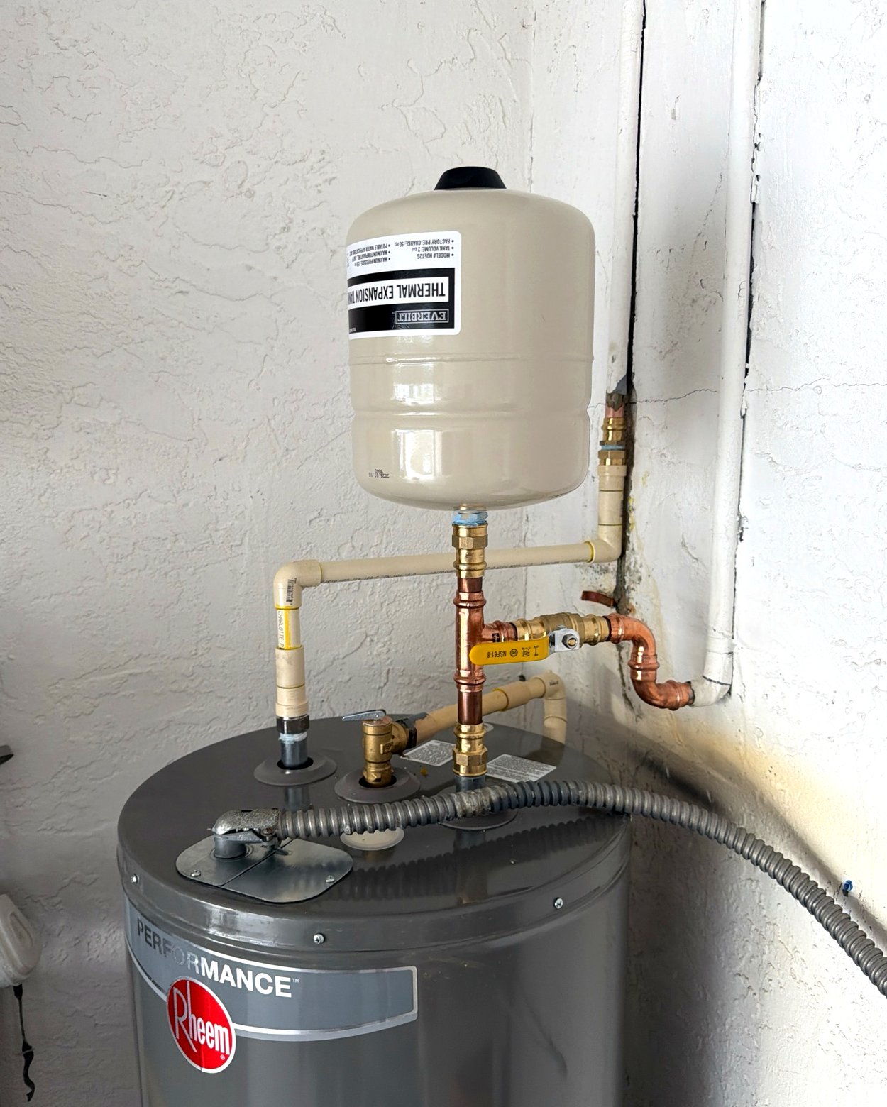 New copper, brass shut-off valve and thermal expansion tank on top of a replacement heater.