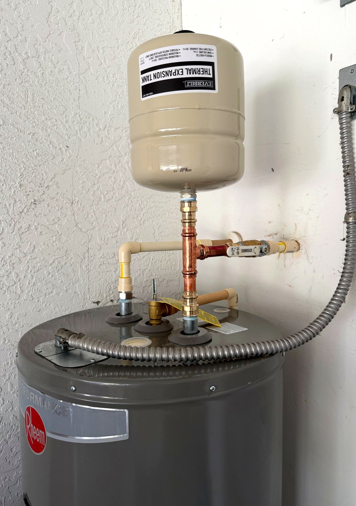 Newly installed water heater with a thermal expansion tank and clean copper connections.